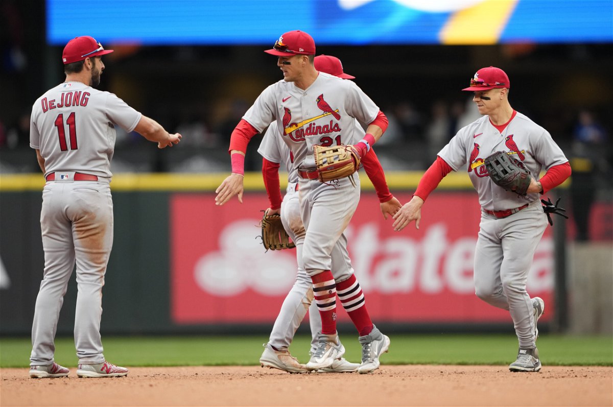 St. Louis Cardinals' Paul DeJong (11) greets Lars Nootbaar, center, and Tyler O'Neill, right, as they celebrate a 7-3 victory over the Seattle Mariners in a baseball game, Sunday, April 23, 2023, in Seattle. 
