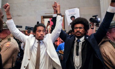 Justin Pearson and Justin Jones raise their hands after being expelled from their seats in the Tennessee House in Nashville Thursday.