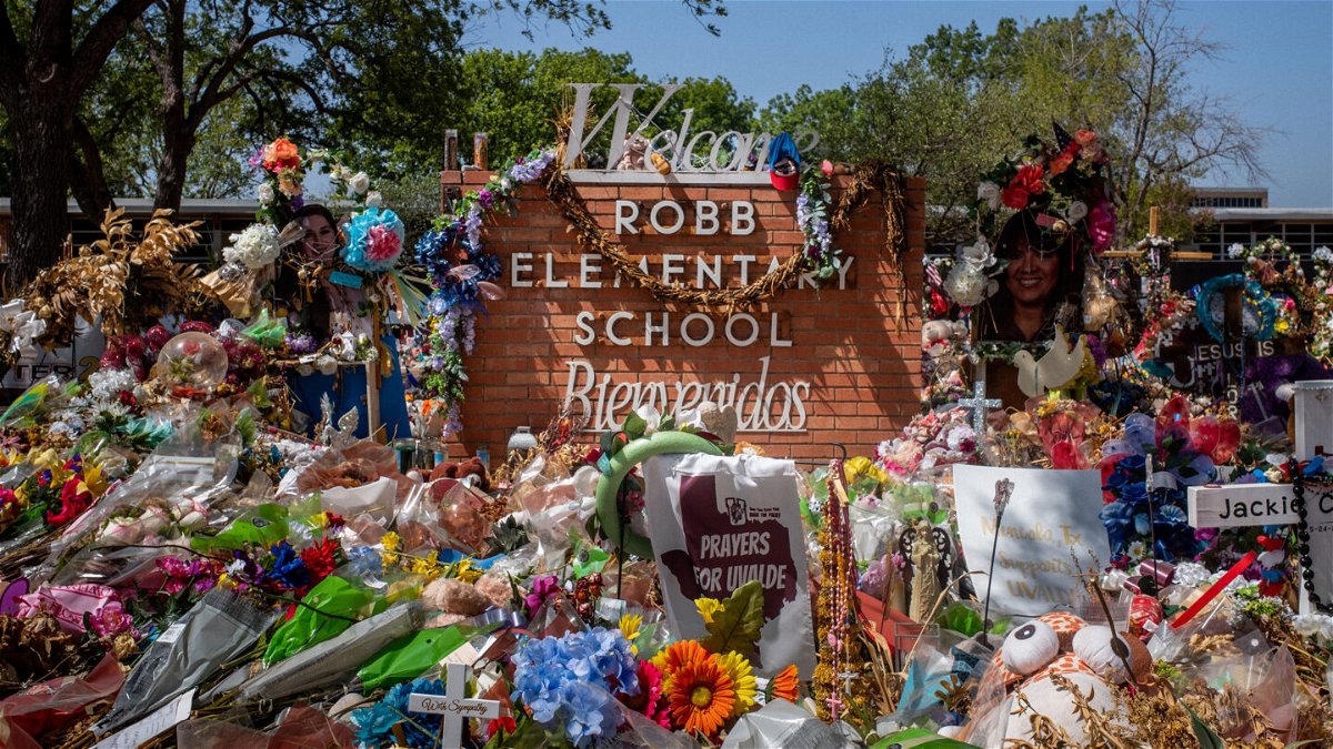 <i>Brandon Bell/Getty Images/FILE</i><br/>The Robb Elementary School sign is covered in flowers and gifts on June 17 in Uvalde