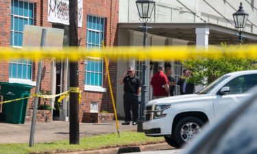 Law enforcement officers investigate the day after the shooting at a venue in downtown Dadeville