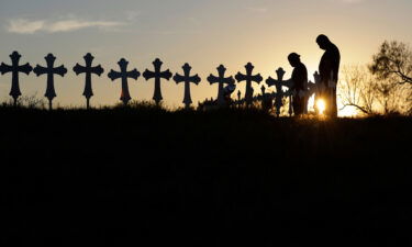 Kenneth and Irene Hernandez pay their respects as they visit a makeshift memorial with crosses placed near the scene of a shooting at the First Baptist Church on Nov. 6