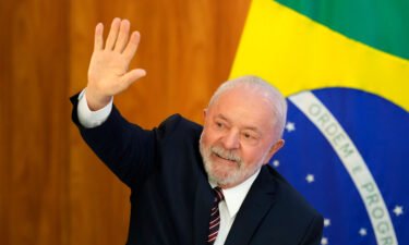 Lula waves as he arrives for a ministerial meeting at Planalto Palace in Brasilia on Monday