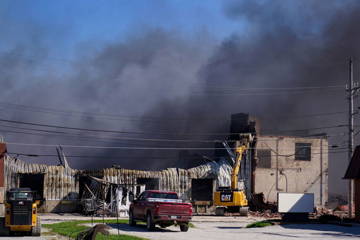<i>Michael Conroy/AP</i><br/>Workers knock down a section of site of an industrial fire the area as smoke billows from the site in Richmond
