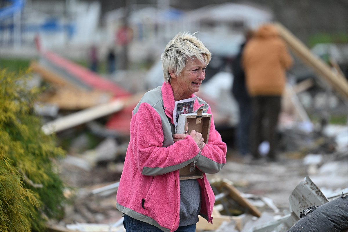 <i>Jon Cherry/Reuters</i><br/>Debbie Lowdermilk holds photographs as she reacts while looking at the destroyed school she owns the day after a reported tornado hit Sullivan