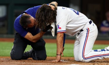 An athletic trainer for the Texas Rangers tends to Josh Smith after he was hit in the face by a pitch in the third inning against the Baltimore Orioles at Globe Life Field on Monday.