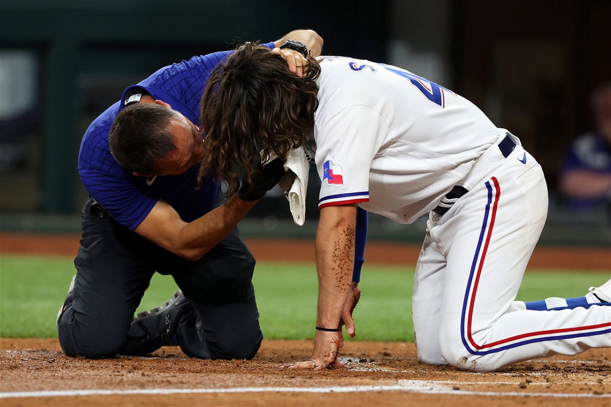 <i>Richard Rodriguez/Getty Images</i><br/>An athletic trainer for the Texas Rangers tends to Josh Smith after he was hit in the face by a pitch in the third inning against the Baltimore Orioles at Globe Life Field on Monday.