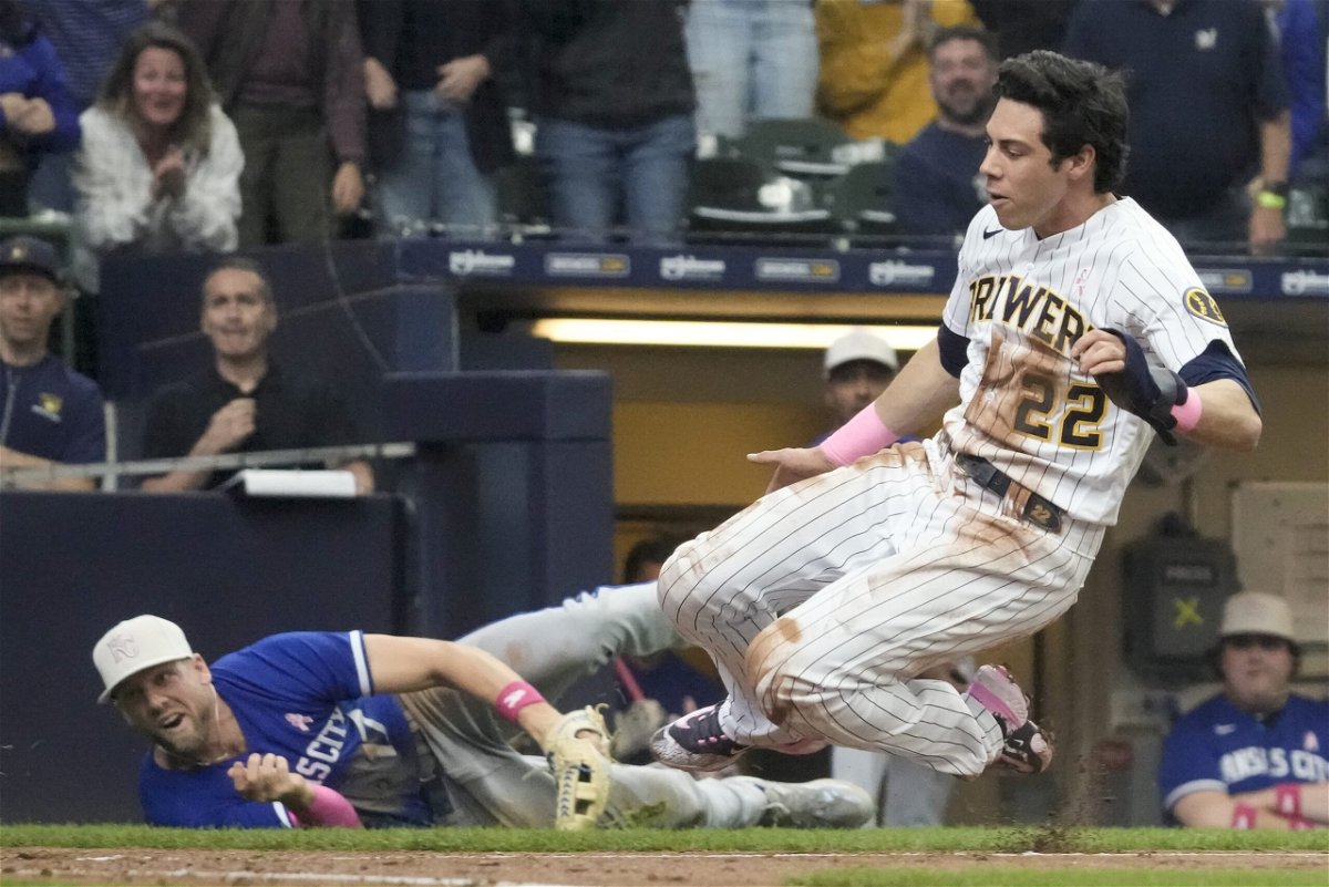 Milwaukee Brewers' Christian Yelich scores past Kansas City Royals' Hunter Dozier during the third inning of a baseball game Sunday, May 14, 2023, in Milwaukee.