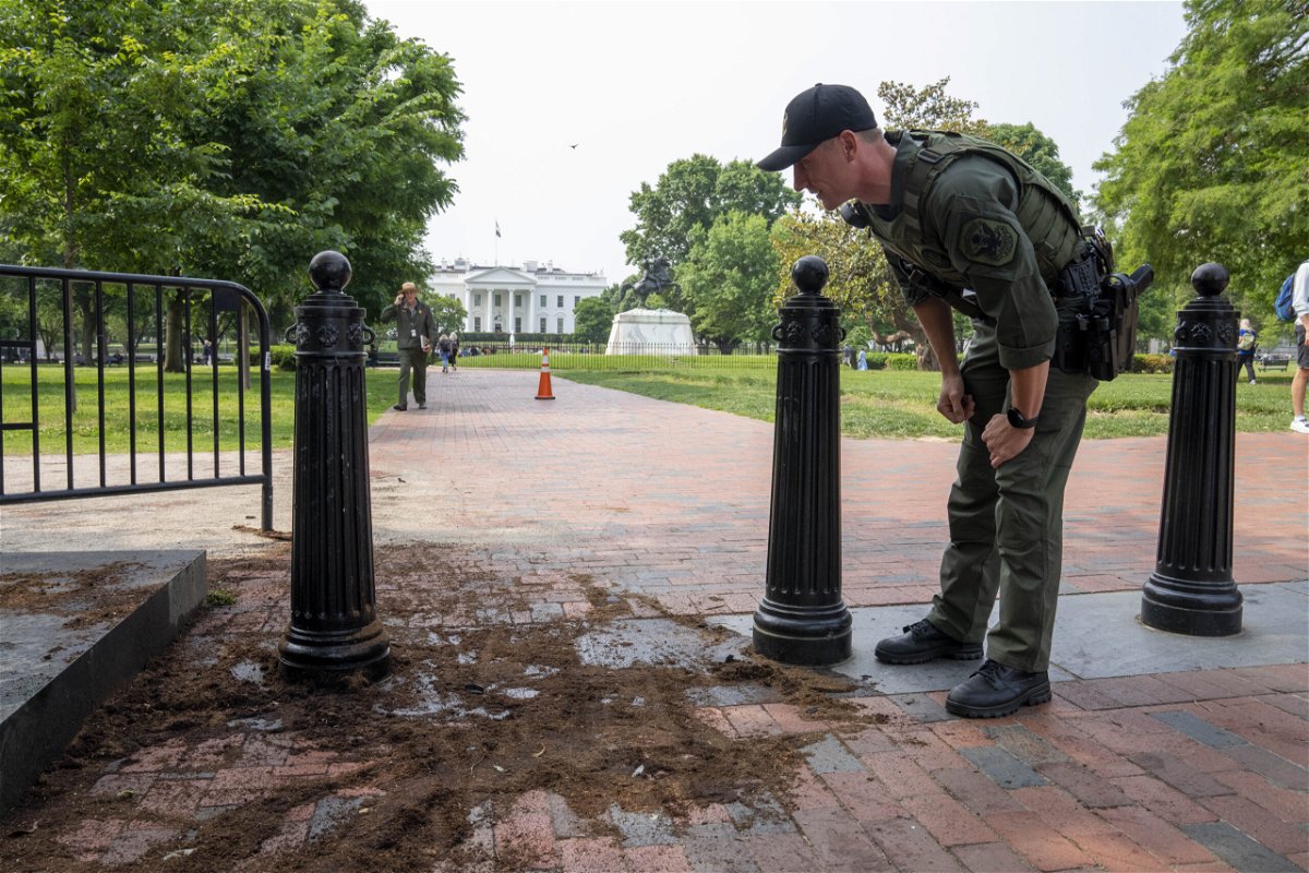 A U.S. Park Police officer inspects a security barrier for damage in Lafayette Square park near the White House, Tuesday, May 23, 2023, in Washington. A man police believe intentionally crashed a U-Haul truck into a security barrier at Lafayette Square park, across from the White House has been arrested and identified as a 19-year-old suburban St. Louis resident. No one was injured.