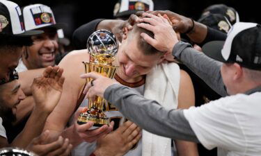 Denver Nuggets center Nikola Jokic surrounded by teammates after accepting the series MVP trophy after Game 4 of the NBA basketball Western Conference Final series on Monday.