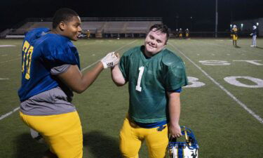 A teammate jokes with Caden Cox on October 6