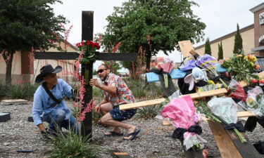 Muralist Roberto Marquez and his friend Israel Gil erect a memorial to honor the victims on the mall shooting.