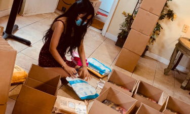 Emily Bhatnagar opening packages of books. She received so many books for her dad's birthday that they filled up her parents' bread shop in  suburban Maryland.