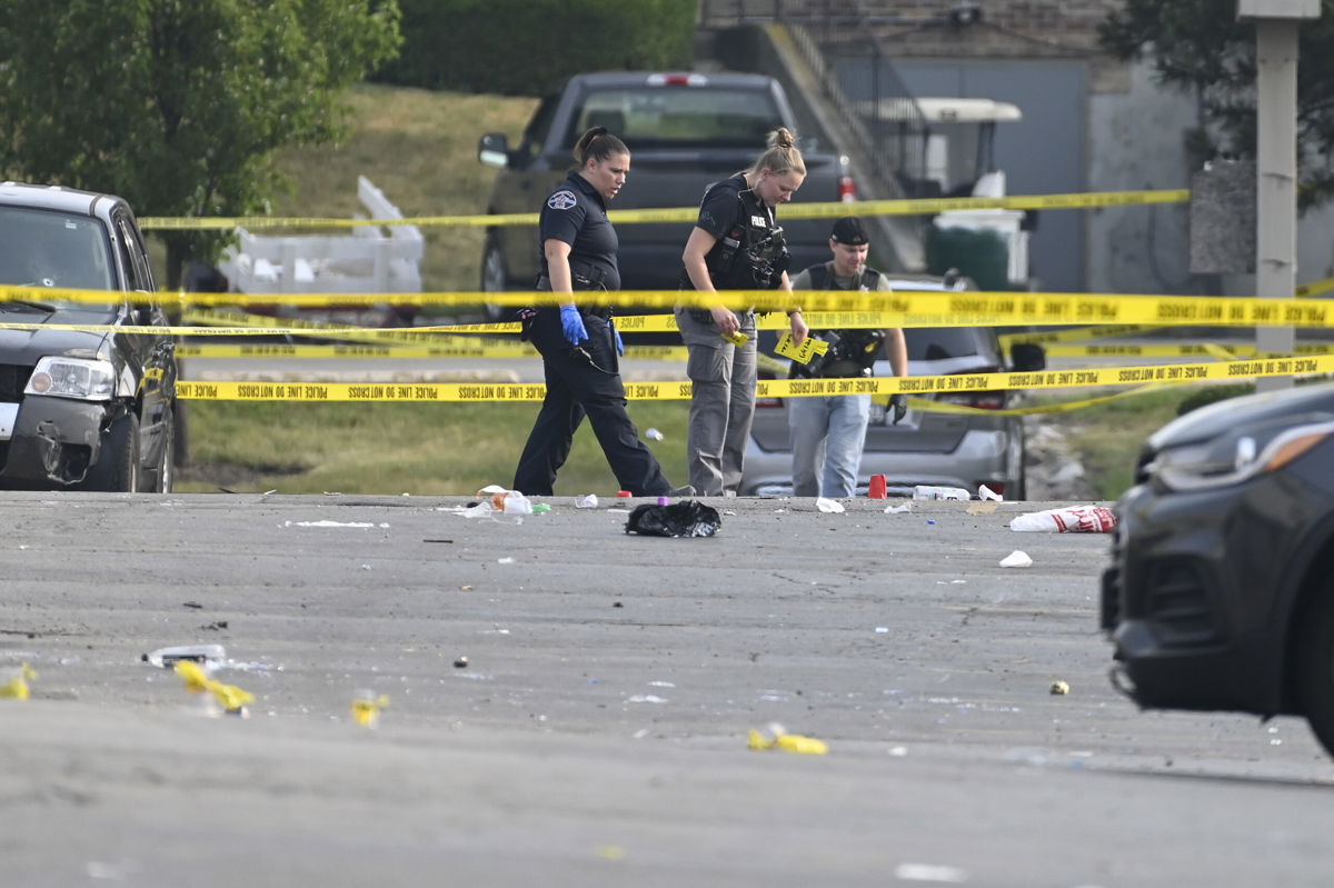 Investigators look over the scene of an overnight mass shooting at a strip mall in Willowbrook, Ill., Sunday, June 18, 2023. 