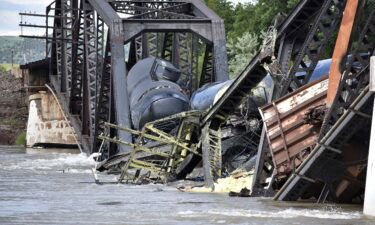 Several train cars are immersed in the Yellowstone River after a bridge collapse near Columbus