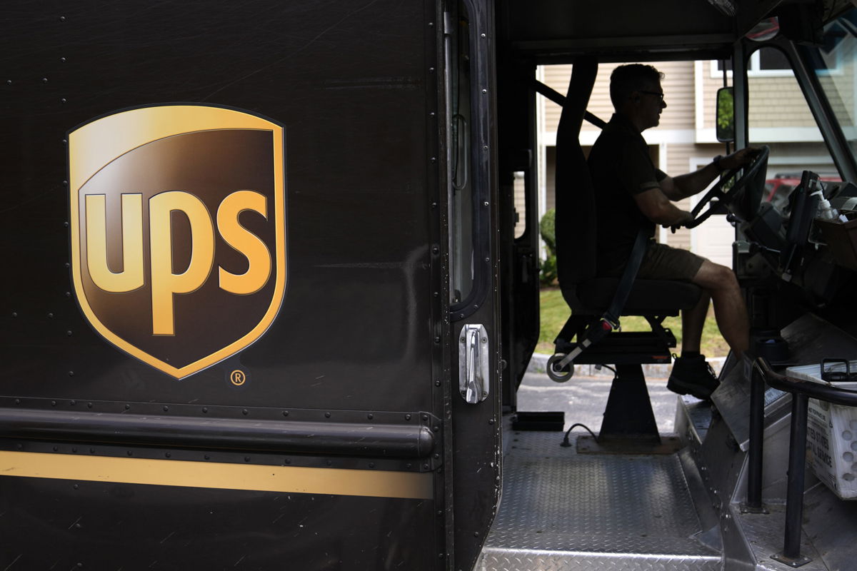 FILE - United Parcel Service driver Hudson de Almeida steers through a neighborhood while delivering packages, Friday, June 30, 2023, in Haverhill, Mass. UPS has reached a contract agreement with its 340,000-person strong union Tuesday, July 25, averting a strike that had the potential to disrupt logistics nationwide for businesses and households alike. 