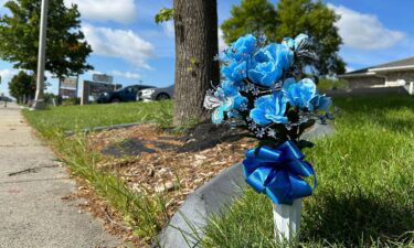 Flowers rest near the site where one police officer was fatally shot and two others were critically wounded on July 14.