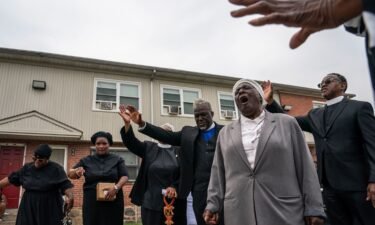 Members of the Kingdom Life Church pray at the site of a mass shooting in the Brooklyn Homes neighborhood on July 2.