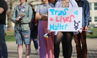 A demonstrator listens to speakers at a rally held in support of transgender youth in Kansas. It comes amid a raft of anti-transgender legislation in the Sunflower State.