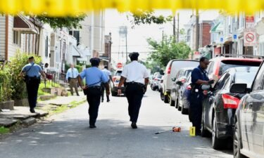 Police officers on July 4 investigate the scene of Monday night's mass shooting in southwest Philadelphia.