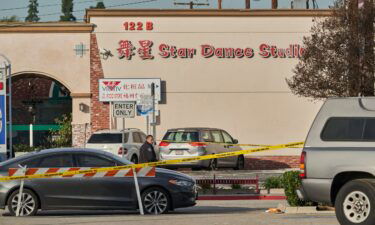 A Monterey Park police officer stands outside the Star Dance Studio where a gunman killed 11 people in Monterey Park