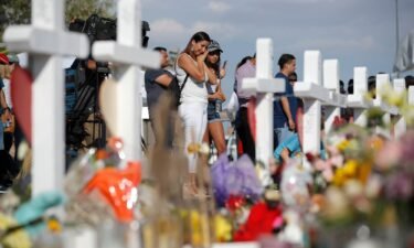People visit a makeshift memorial at the site of the August 2019 shooting in El Paso