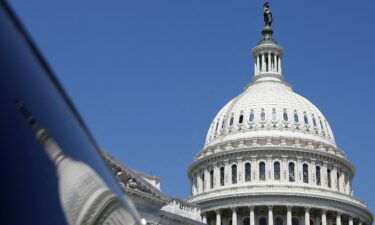 The dome of the US Capitol is reflected in a window on Capitol Hill in Washington