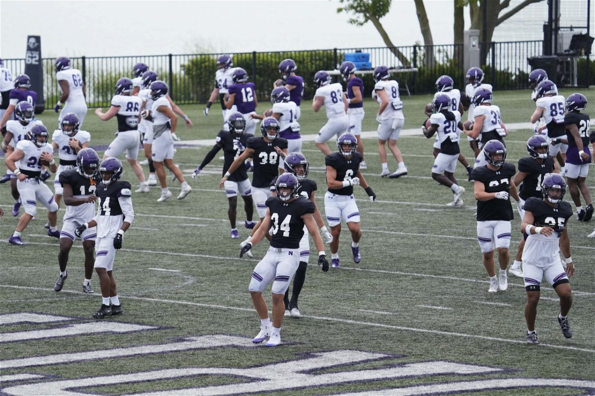 Northwestern football players warm up during team's practice in Evanston, Ill., Wednesday, Aug. 9, 2023. 
