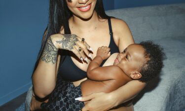 Model Essence Tatiana breastfeeds while wearing the Savage X Fenty Floral Lace Maternity Bralette in the color Black Caviar.