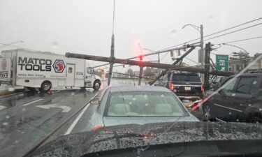 A driver is seen stuck in a car after downed electrical poles crash on vehicles in Westminster