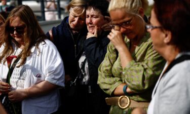 People react as fans gather outside late Irish singer Sinead O'Connor's former home to say their last goodbye to her on the day of her funeral procession.