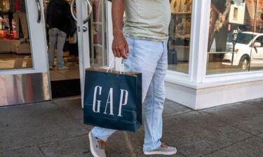 A shopper carries a Gap bag outside a store in San Francisco on April 27. Gap reported a mixed second quarter and a decline in sales across all its brands.