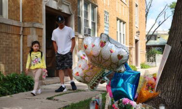 Neighbors pass by a memorial for a 9-year-old girl shot and killed outside of her Portage Park apartment on August 5 in Chicago.