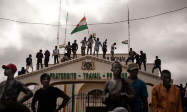 Protesters hold a Niger flag during a demonstration on independence day in Niamey on August 3