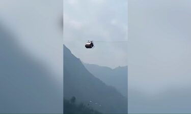 Rescuers in Pakistan are trying to reach six children and two adults trapped 900 feet in the air.