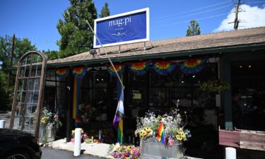 A Pride flag ripped off its flagpole is seen outside the entrance to the Mag.Pi clothing in Cedar Glen