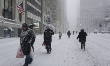 People walk on snow as a winter storm hits New York City on January 23