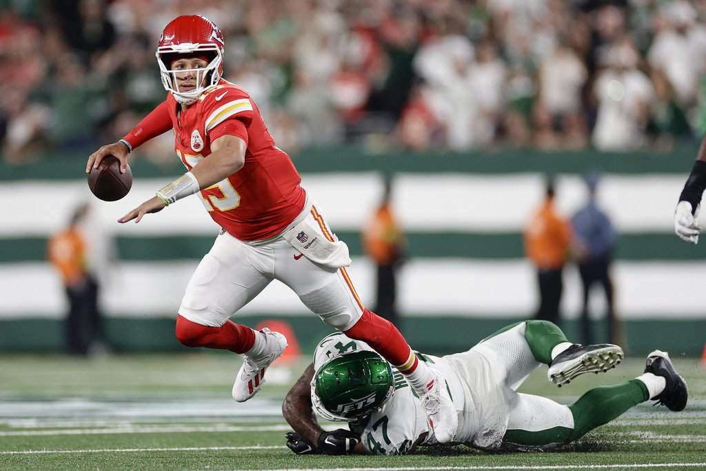 Kansas City Chiefs quarterback Patrick Mahomes (15) is tripped up by New York Jets linebacker Bryce Huff (47) as he throws during the second quarter of an NFL football game, Sunday, Oct. 1, 2023, in East Rutherford, N.J. 