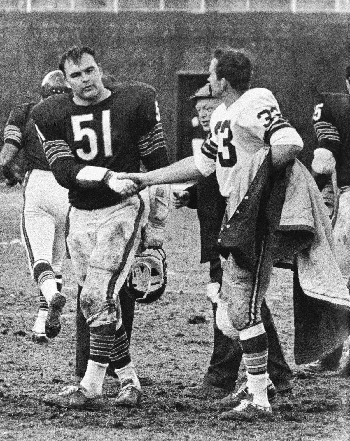 FILE - Chicago Bears' Dick Butkus (51) shakes hands with Green Bay Packers' Jim Grabowski after an NFL football game in Chicago, Nov. 26, 1967. Butkus and Grabowski were teammates at the University of Illinois several years ago. Butkus, a fearsome middle linebacker for the Bears, has died, the team announced Thursday, Oct. 5, 2023. He was 80. According to a statement released by the team, Butkus' family confirmed that he died in his sleep overnight at his home in Malibu, California.