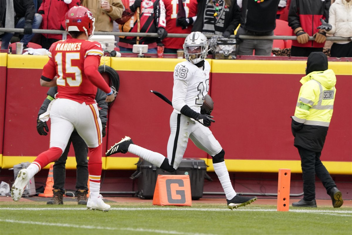 Las Vegas Raiders cornerback Jack Jones scores after intercepting a pass and running it back for a touchdown as Kansas City Chiefs quarterback Patrick Mahomes (15) watches during the first half of an NFL football game Monday, Dec. 25, 2023, in Kansas City, Mo. 