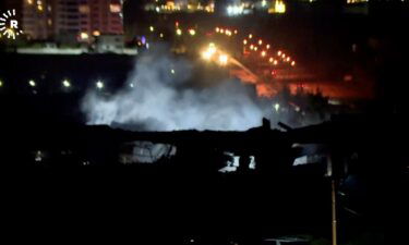 Authorities and others gather near the site where missiles hit near the US consulate in Erbil