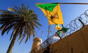 The Kataib Hezbollah militia group's flag flies at a protest outside the US Embassy in Baghdad