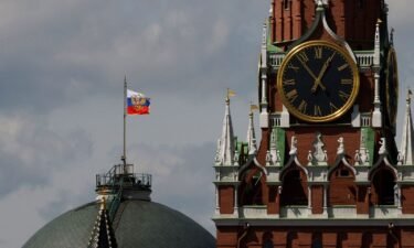 The Russian flag flies on the dome of the Kremlin Senate building behind Spasskaya Tower