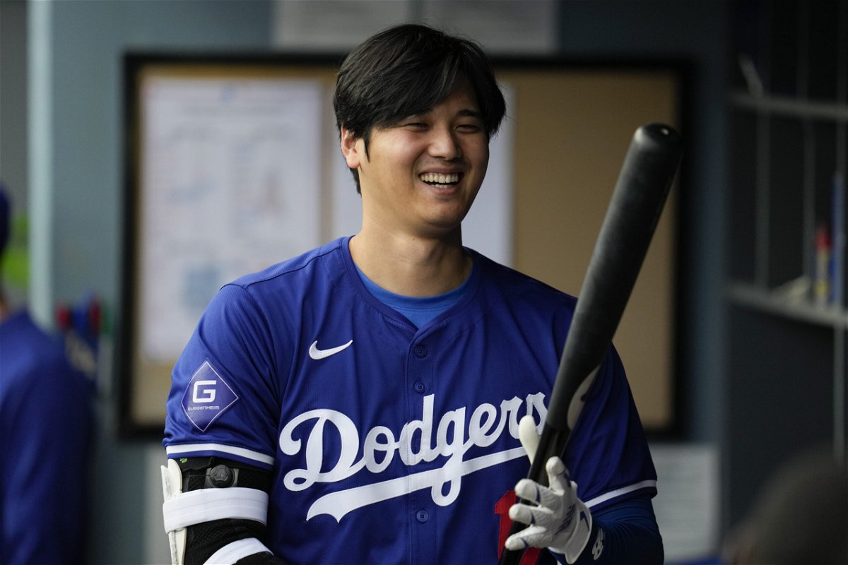 Los Angeles Dodgers designated hitter Shohei Ohtani (17) prepares his bat in the dugout during the first inning of a spring training baseball game against the Los Angeles Angels in Los Angeles, Sunday, March 24, 2024.