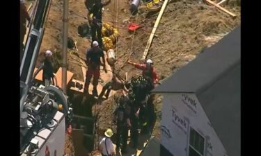 Emergency crews rescued a worker who was buried up to his chest in a trench 20 feet below ground level for more than three hours on Friday
