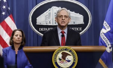 U.S. Attorney General Merrick Garland speaks alongside Deputy Attorney General Lisa Monaco during a news conference at the Department of Justice Building on March 21