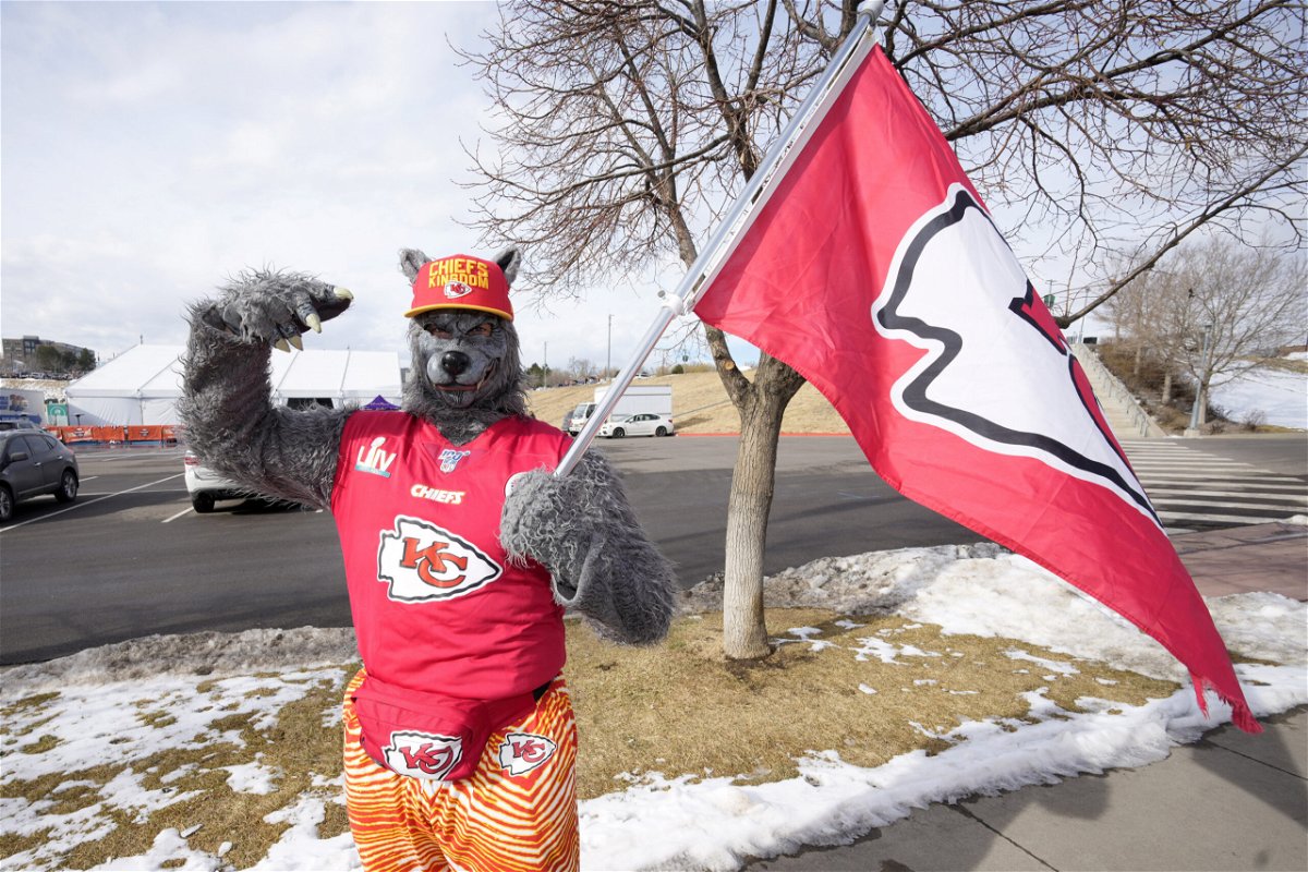 FILE - A Kansas City Chiefs fan, Chiefsaholic, poses for photos while walking toward Empower Field at Mile High before an NFL football game between the Denver Broncos and the Chiefs, Jan. 8, 2022, in Denver. An Oklahoma judge has ordered the Kansas City Chiefs superfan known as “ChiefsAholic” who admitted to a series of bank robberies to pay $10.8 million to a bank teller he threatened and assaulted with a gun. 