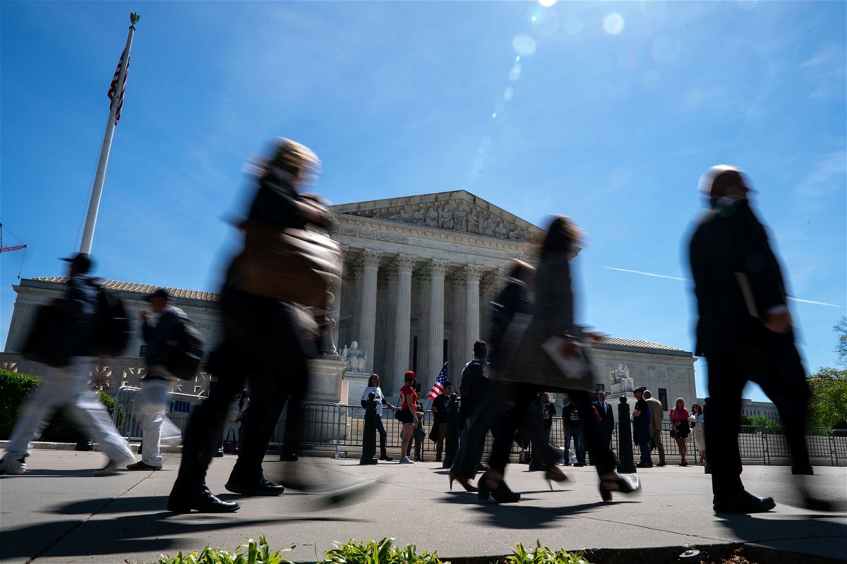 People walk outside of the Supreme Court on April 16, in Washington, DC. The court will review President Joe Biden’s 