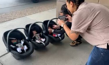 Kahea Benitez-Kauo taking photos of her three newborn children outside of the hospital.
