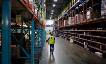 A worker walks down an aisle at Southern Glazer's Wine and Spirits LLC distribution center in Louisville