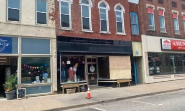The windows of a downtown Chippewa Falls business are boarded up Tuesday after the apartment above it caved into the shop overnight.